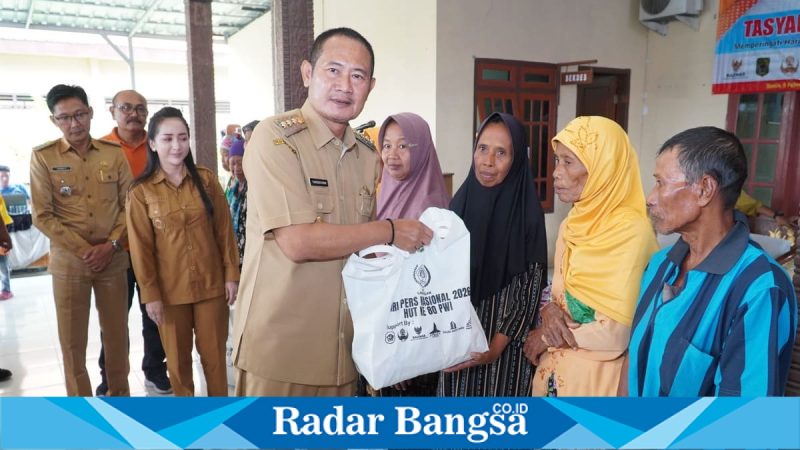 Bupati Lamongan Yuhronur Efendi menyerahkan bantuan pada bakti sosial PWI Lamongan di Desa Kedungkumpul, Senin (9/2/2026). (Foto Dok Ho/RadarBangsa.co.id)