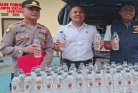 Petugas Satreskrim Polres Sampang menunjukkan barang bukti arak Bali hasil pengungkapan di Terminal Trunojoyo, Sabtu (7/2/2026). (Foto Dok Ho/RadarBangsa.co.id)