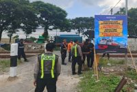 Petugas Satlantas Polres Lamongan memasang banner imbauan keselamatan di Perlintasan Sebidang JPL 266 Babat, Jumat (6/2/2026). (Foto Dok Ho/RadarBangsa.co.id)