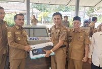 Bupati Bangkalan Lukman Hakim menyerahkan fasilitas ATM SAMSAT QRIS di Kantor Kecamatan Geger, Senin (16/3/2026). (Foto Dok Ho/RadarBangsa.co.id)
