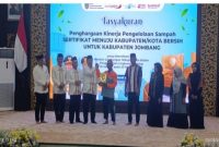 Bupati Jombang Warsubi menyerahkan kejutan hadiah umrah kepada petugas kebersihan saat tasyakuran prestasi nasional pengelolaan sampah di Pendopo Jombang, Senin (2/3/2026). (Foto Dok Ho/RadarBangsa.co.id)