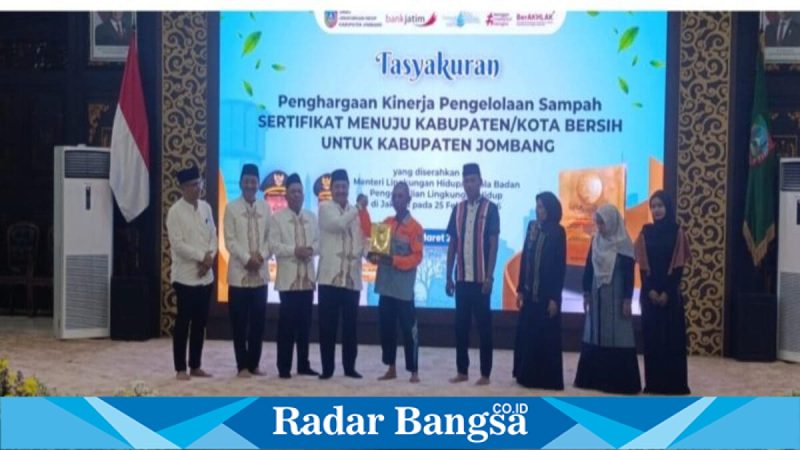 Bupati Jombang Warsubi menyerahkan kejutan hadiah umrah kepada petugas kebersihan saat tasyakuran prestasi nasional pengelolaan sampah di Pendopo Jombang, Senin (2/3/2026). (Foto Dok Ho/RadarBangsa.co.id)