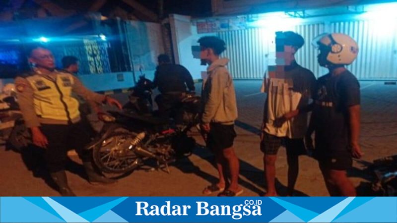 Petugas Polsek Deket saat mengamankan pelaku balap liar di depan SPBU Dinoyo, Sabtu (9/5/2026). (Foto Dok Ho/RadarBangsa.co.id)