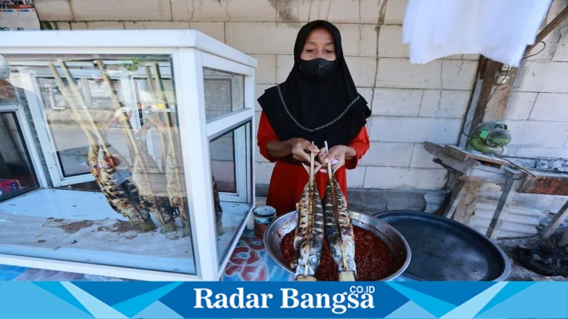 Pedagang ikan asap khas Pantai Blimbingsari Banyuwangi melayani pembeli. Minggu, 10 Mei 2026  (Foto Dok Ho/RadarBangsa.co.id)