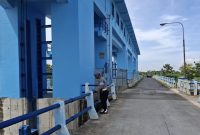 Petugas Polsek Laren melakukan pemantauan tinggi muka air Bengawan Solo di Pintu Air Floodway Plangwot, Minggu (28/6/2026). (Foto Dok Ho/RadarBangsa.co.id)