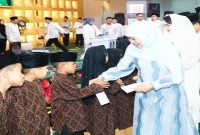 Gubernur Jawa Timur Khofifah Indar Parawansa menyerahkan santunan kepada anak yatim pada peringatan Tahun Baru Islam 1 Muharram 1448 Hijriah yang dirangkai dengan dzikir dan doa bersama di Masjid Raya Islamic Centre Jawa Timur, Surabaya, Senin, 15 Juni 2026. (Foto Dok Ho/RadarBangsa.co.id)