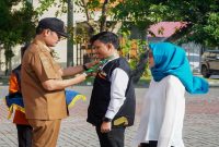 Bupati Lamongan Yuhronur Efendi menyematkan tanda pengenal kepada petugas Sensus Ekonomi 2026 saat apel pencanangan dan pelepasan petugas di Halaman Pemkab Lamongan, Senin, 15 Juni 2026. (Foto Dok Ho/RadarBangsa.co.id)