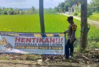 Anggota Polsek Laren memasang papan imbauan kepada petani sebagai upaya mengantisipasi bahaya sengatan listrik akibat penggunaan jebakan tikus di area persawahan, Jumat (26/6/2026). (Foto Dok Ho/RadarBangsa.co.id)
