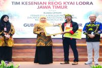 Gubernur Jawa Timur Khofifah Indar Parawansa menyerahkan penghargaan kepada Tim Kesenian Kyai Lodra peraih Juara Umum Festival Nasional Reog Ponorogo XXXI di Gedung Negara Grahadi, Surabaya. (Foto Dok Ho/RadarBangsa.co.id)