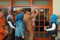 Bupati Lamongan Yuhronur Efendi melakukan penempelan stiker tanda telah didata kepada warga saat pelaksanaan Sensus Ekonomi 2026 di Lamongan, Senin, 15 Juni 2026. (Foto Dok Ho/RadarBangsa.co.id)