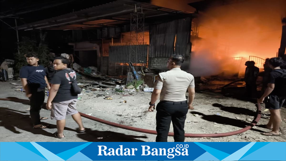 Petugas Polsek Sukodadi bersama Pemadam Kebakaran Kabupaten Lamongan memadamkan kebakaran gudang rosokan di Desa Madulegi, Kecamatan Sukodadi, Jumat (10/7). (Foto Dok Ho/RadarBangsa.co.id)