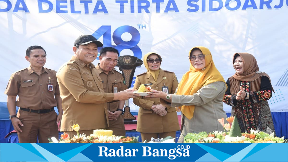 Bupati Sidoarjo Subandi memotong tumpeng sebagai simbol peringatan HUT ke-48 Perumda Delta Tirta di halaman kantor Perumda Delta Tirta, Sidoarjo, Senin (6/7/2026). (Foto Dok Ho/RadarBangsa.co.id)