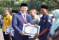 Bupati Lamongan Yuhronur Efendi memberikan piagam penghargaan pada Upacara Peringatan Hari Koperasi ke-79 di Halaman Pemkab Lamongan, Minggu (12/7/2026). (Foto Dok Ho/RadarBangsa.co.id)