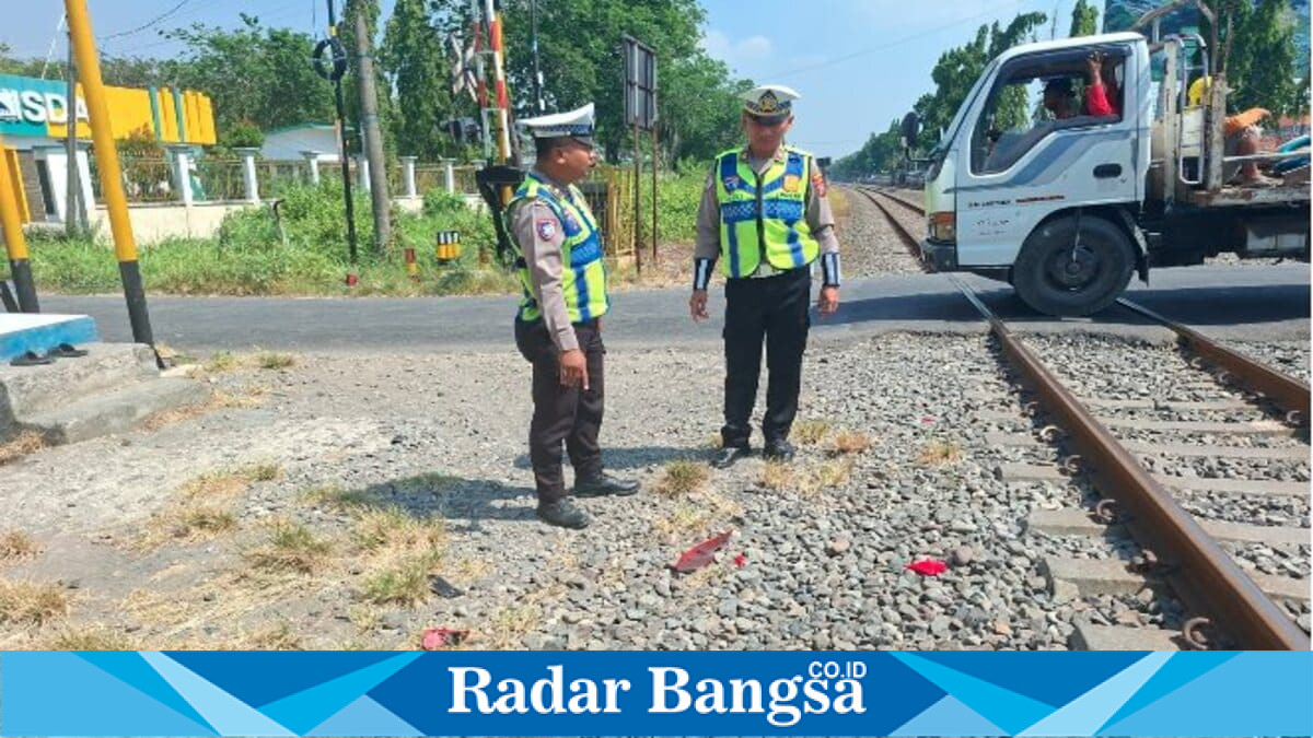 Petugas Satlantas Polres Lamongan melakukan penanganan di lokasi kecelakaan yang melibatkan pengendara sepeda motor dan Kereta Api Commuter Line Arjonegoro di perlintasan sebidang Desa Sukodadi, Rabu (8/7/2026).