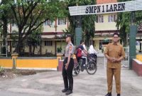 Personel Polsek Laren mengatur arus lalu lintas di depan SMP Negeri 1 Laren, Lamongan, Jumat (17/7/2026). (Foto Dok Ho/RadarBangsa.co.id)