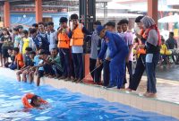Personel Satpolairud Polres Lamongan memberikan pelatihan berenang dan teknik pertolongan di air kepada 80 santri Pondok Pesantren Modern Al Manar di Kolam Renang Malindo, Kecamatan Dukun, Gresik, Kamis (16/7/2026). (Foto Dok Ho/RadarBangsa.co.id)