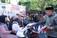 Bupati Asahan Taufik Zainal Abidin didampingi Wakil Bupati dan unsur Forkopimda menyerahkan Bendera Merah Putih secara simbolis kepada tokoh agama dan tokoh masyarakat pada Gerakan Pembagian Bendera Merah Putih di Jalan Madong Lubis, Kisaran, Kamis (6/8/2026). (Foto Dok Ho/RadarBangsa.co.id)