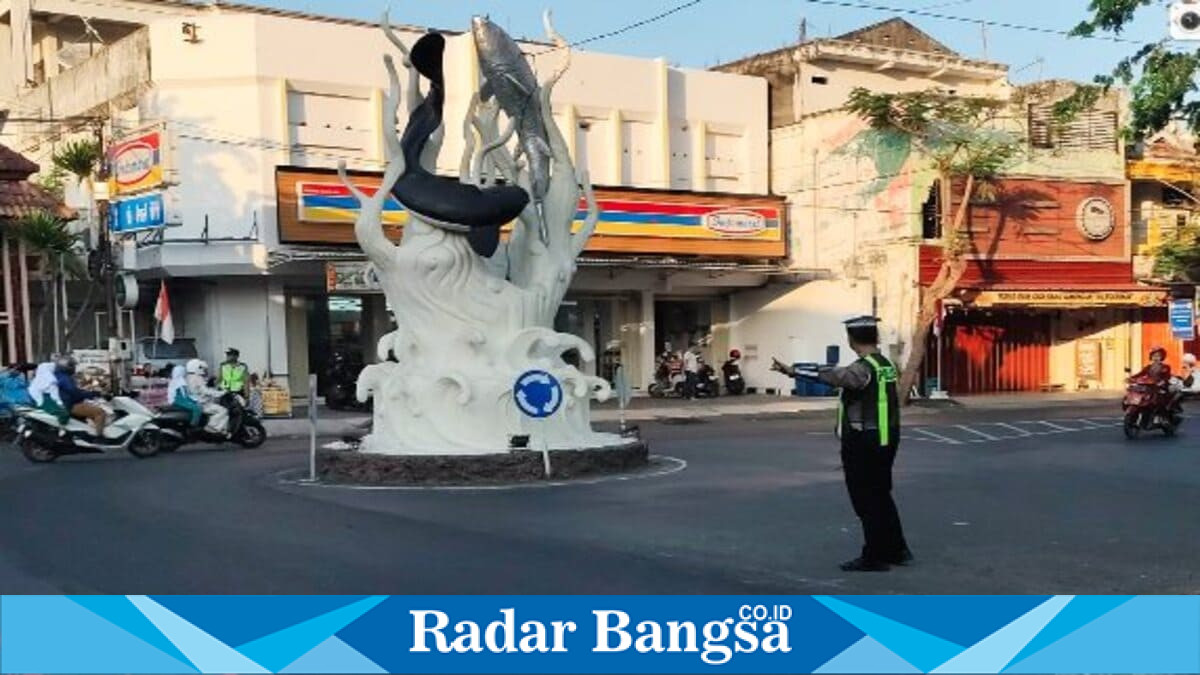 Anggota Polres Lamongan melaksanakan Commander Wish Layanan Pagi dengan memberikan pelayanan dan pengaturan arus lalu lintas di kawasan Tugu Bandeng Lele, Lamongan, saat aktivitas masyarakat pada Senin (3/8/2026). (Foto Dok Ho/RadarBangsa.co.id)