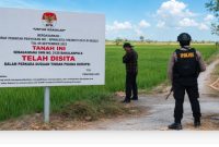 Penyidik KPK dan warga berada di lokasi tanah yang diduga disita terkait perkara korupsi pembangunan Gedung Pemkab Lamongan di Desa Puter, Kecamatan Kembangbahu, Kamis (6/8/2026). (Foto Dok Ho/RadarBangsa.co.id)