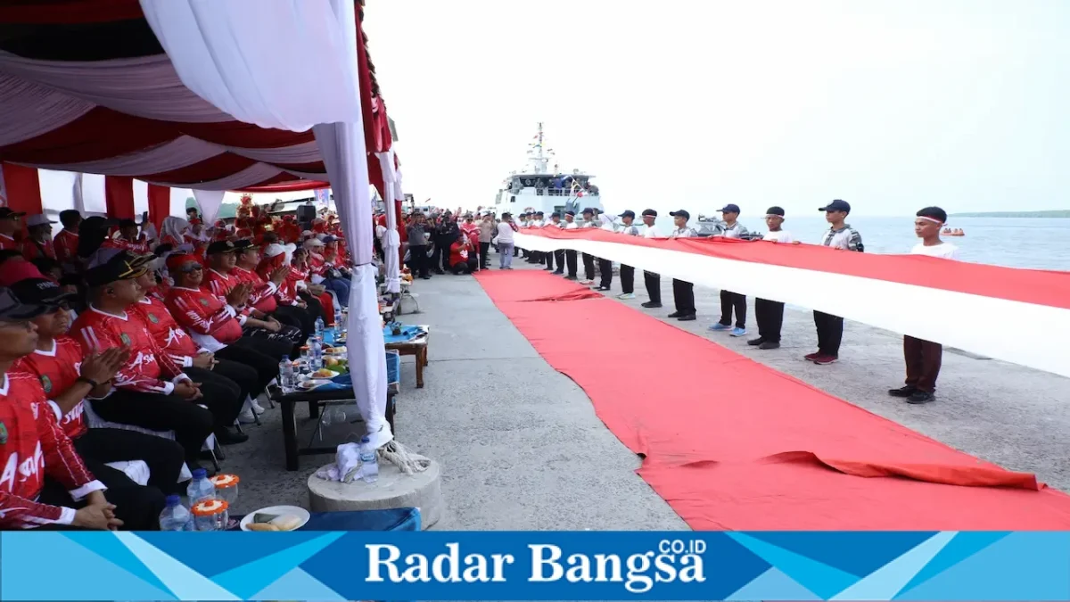 Bupati Asahan Taufik Zainal Abidin saat mengibarkan bendera Merah Putih raksasa berukuran 2 x 50 meter di Muara Selat Malaka, Asahan, Selasa (11/8/2026). (Foto Dok Ho/RadarBangsa.co.id)