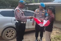 Sipropam Polres Pelalawan membagikan dan memasang Bendera Merah Putih di Desa Rantau Baru, Kecamatan Pangkalan Kerinci, Kabupaten Pelalawan, Selasa, 11 Agustus 2026. (Foto Dok Ho/RadarBangsa.co.id)