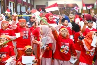 Anak-anak yang mengikuti upacara dari luar pagar Gedung Negara Grahadi di Surabaya menghadiri perayaan “Anak Hebat Indonesia Kuat”, Selasa (18/8). (Foto Dok Ho/RadarBangsa.co.id)