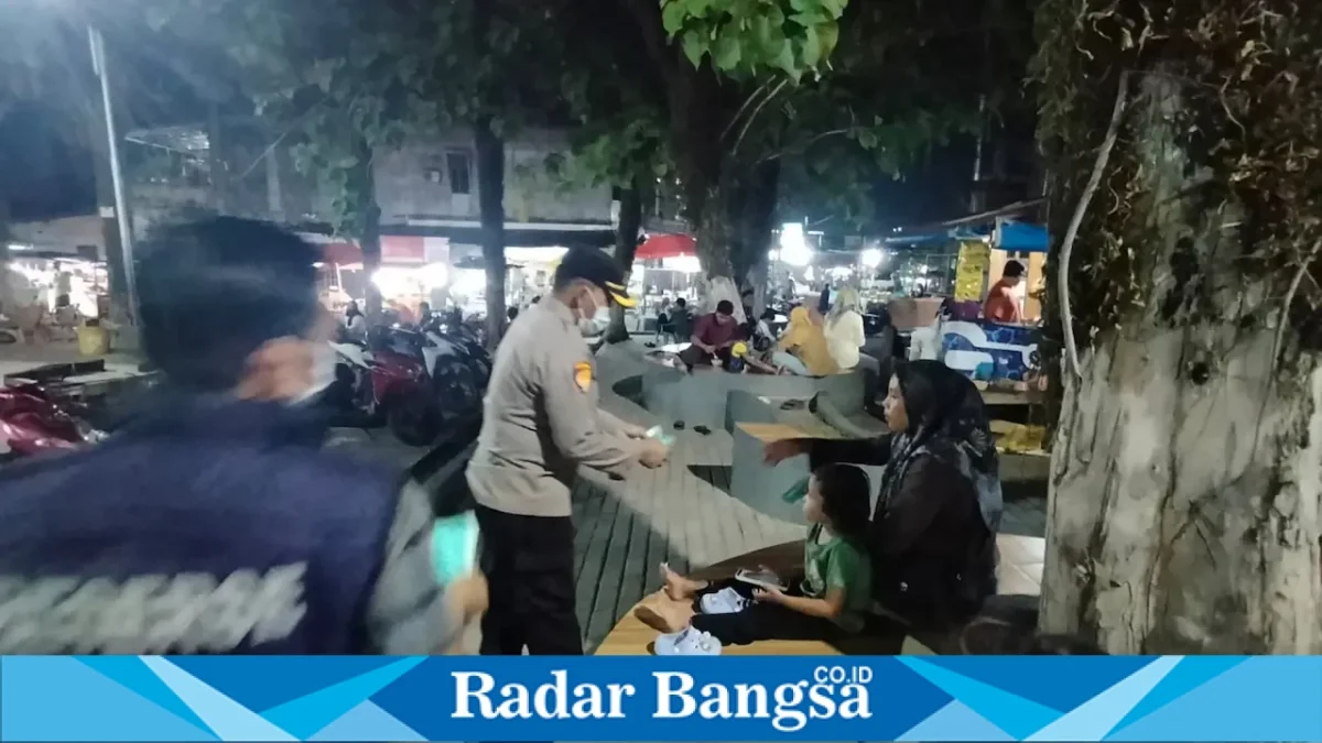 Personel Polres Pelalawan membagikan masker kepada warga di area Taman Bola Mini Soccer Pangkalan Kerinci, Selasa (25/8/2026) malam. (Foto Dok Ho/RadarBangsa.co.id)