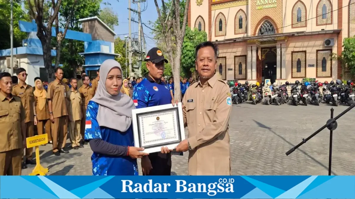 Kepala Dinas Pendidikan Kabupaten Lamongan Drs. Sholikin, M.Pd. menyerahkan sertifikat kepada perwakilan peserta Retreat Bela Negara di Lapangan Dinas Pendidikan Lamongan, Senin (28/9/2026). (Dok. Ho/RadarBangsa.co.id)