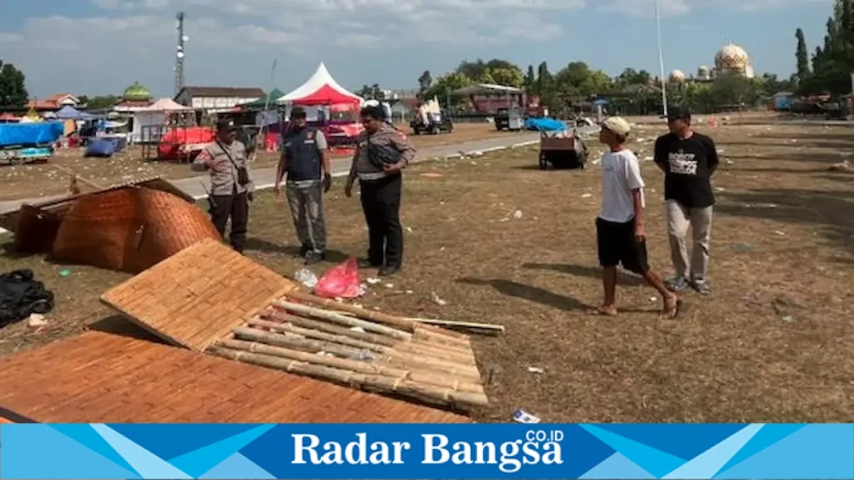 Petugas Polsek Babat menangani tenda pameran yang roboh diterjang angin kencang di Lapangan Sawunggaling, Sabtu (12/9/2026). (Foto Dok Ho/RadarBangsa.co.id)