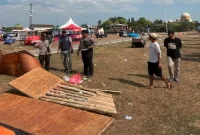 Petugas Polsek Babat menangani tenda pameran yang roboh diterjang angin kencang di Lapangan Sawunggaling, Sabtu (12/9/2026). (Foto Dok Ho/RadarBangsa.co.id)