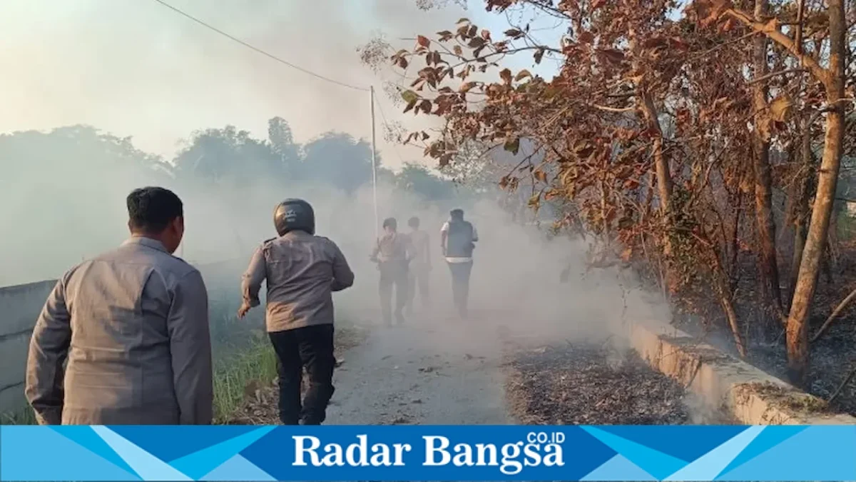 Petugas Polsek Lamongan Kota bersama Damkar memadamkan kebakaran lahan di Desa Tanjung, Senin (7/9/2026). (Foto Dok Ho/RadarBangsa.co.id)