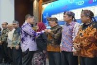 Bupati Lamongan Yuhronur Efendi saat memasang pin dalam kegiatan HLM ETPD Kabupaten Lamongan yang membahas percepatan digitalisasi transaksi daerah, Kamis (3/9/2026). (Foto Dok Ho/RadarBangsa.co.id)