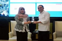 Ning Lia menyerahkan penghargaan kepada Wali Kota Surabaya Eri Cahyadi dalam sebuah kegiatan di Surabaya. (Dok. Ho/RadarBangsa.co.id)