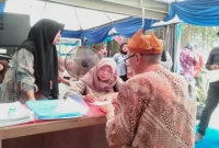 Petugas Dispendukcapil Kabupaten Pasuruan melayani warga di stan administrasi kependudukan Pekan Raya Pasuruan di Taman Candra Wilwatikta, Pandaan. (Dok. Ho/RadarBangsa.co.id)