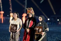 Direktur Utama InJourney Maya Watono berkebaya putih bersama Bupati Banyuwangi Ipuk Fiestiandani yang mengenakan omprog saat Gandrung Sewu 2026 di Pantai Marina Boom. (Dok. Ho/RadarBangsa.co.id).