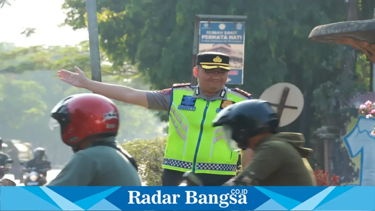Kapolres Lamongan AKBP Adhytiawarman Gautama Putra saat mengatur lalu lintas dan membantu penyeberangan anak sekolah di Lamongan, Senin (19/10/2026). (Dok. Ho/Polres Lamongan)