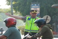 Kapolres Lamongan AKBP Adhytiawarman Gautama Putra saat mengatur lalu lintas dan membantu penyeberangan anak sekolah di Lamongan, Senin (19/10/2026). (Dok. Ho/Polres Lamongan)