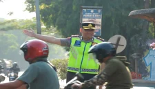 Kapolres Lamongan AKBP Adhytiawarman Gautama Putra saat mengatur lalu lintas dan membantu penyeberangan anak sekolah di Lamongan, Senin (19/10/2026). (Dok. Ho/Polres Lamongan)