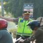 Kapolres Lamongan AKBP Adhytiawarman Gautama Putra saat mengatur lalu lintas dan membantu penyeberangan anak sekolah di Lamongan, Senin (19/10/2026). (Dok. Ho/Polres Lamongan)