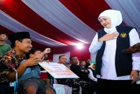 Gubernur Jawa Timur Khofifah Indar Parawansa menyerahkan bantuan dalam kegiatan Sapa Bansos dan Bakti Sosial di Pantai Slopeng, Sumenep, Rabu (14/10/2026). (Dok. Ho/RadarBangsa.co.id)