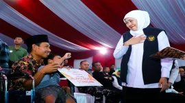 Gubernur Jawa Timur Khofifah Indar Parawansa menyerahkan bantuan dalam kegiatan Sapa Bansos dan Bakti Sosial di Pantai Slopeng, Sumenep, Rabu (14/10/2026). (Dok. Ho/RadarBangsa.co.id)