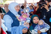 Gubernur Jawa Timur Khofifah Indar Parawansa bersama ibu dan balita penerima bantuan paket gizi di Pacitan. (Dok. Ho/Pemprov Jatim/RadarBangsa.co.id).