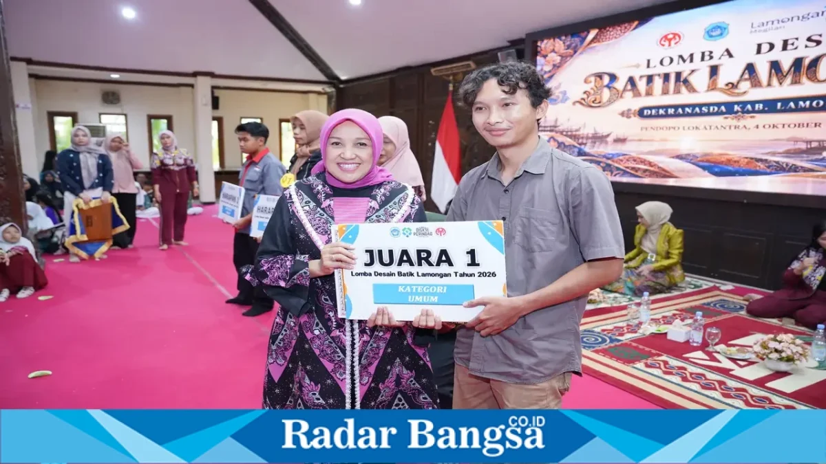 Ketua Dekranasda Kabupaten Lamongan Anis Kartika Yuhronur menyerahkan penghargaan kepada juara 1 kategori umum Lomba Desain Batik Lamongan 2026 di Pendopo Lokatantra, 4 Oktober 2026. (Dok. Ho/RadarBangsa.co.id)