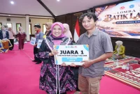 Ketua Dekranasda Kabupaten Lamongan Anis Kartika Yuhronur menyerahkan penghargaan kepada juara 1 kategori umum Lomba Desain Batik Lamongan 2026 di Pendopo Lokatantra, 4 Oktober 2026. (Dok. Ho/RadarBangsa.co.id)
